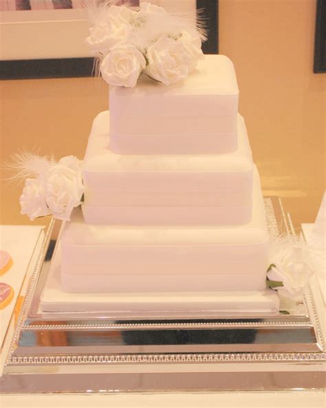 White Square Wedding Cake With White Roses And Feathers White Square