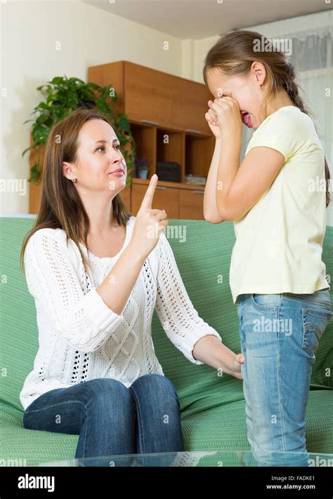 Woman Scolding Crying Little Child At Their Home Interior Stock Photo