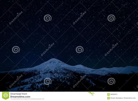 The Starry Sky Above The Snowy Peaks Of The Mountains Stock Photo