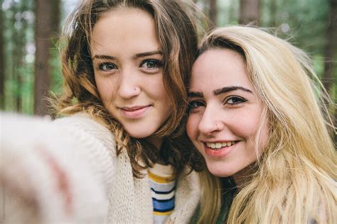 two teenage girls taking a selfie in the woods by stocksy contributor kkgas stocksy