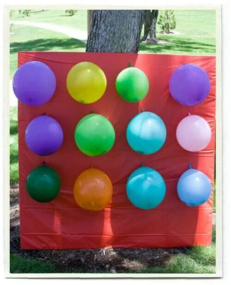 Balloons Are Arranged On A Red Sheet In Front Of A Tree With Grass And Trees