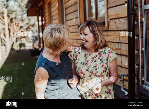 Two Mature Women Years Old Are Talking Cute On Background Of Wooden House Stock Photo Alamy