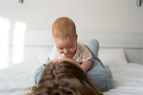 Happy Mother And Sleeping Baby Lie On Bed At Home Baby On Top Of Mom