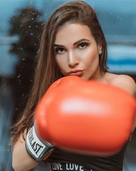 A Woman In Black Shirt And Red Boxing Gloves Posing For The Camera With Her Arm Wrapped Around