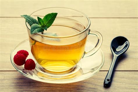 glass cup of green tea with leaves of mint fresh raspberries on stock image image of