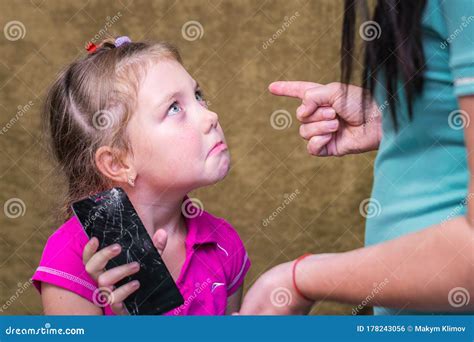 Mamá Castiga A Su Hija Por Un Teléfono Roto Una Niña Pequeña Mira
