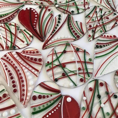 Some Red And Green Glass Hearts On A White Surface