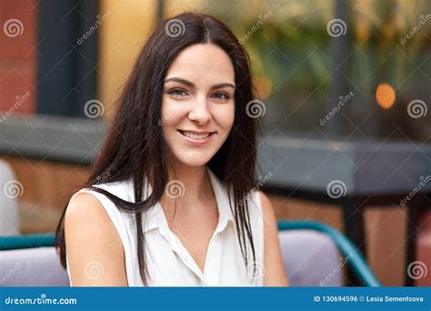 Close Up Shot Of Pleased Attractive Young Woman With Pleasant