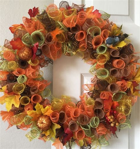 An Orange And Green Wreath On A White Door