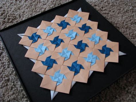 An Origami Star Made Out Of Brown And Blue Paper On A Black Surface