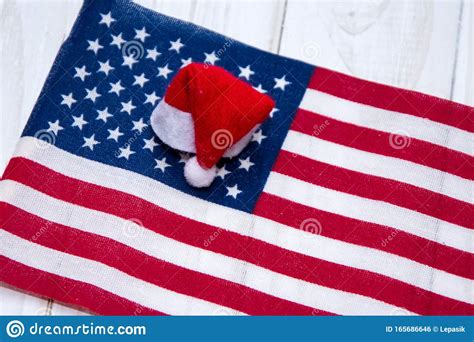 The Christmas Cap Of Santa Claus Lies On The American Flag Concept