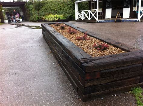 Landscaping xeriscaping raised beds in copper, succulents australian style dry drought garden, raised beds, curving edges. Buckfastleigh raised bed with railway sleepers