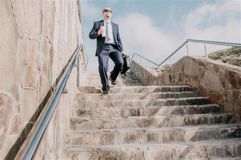 Confident Middle Age Businessman With Briefcase Walking Upstairs Close