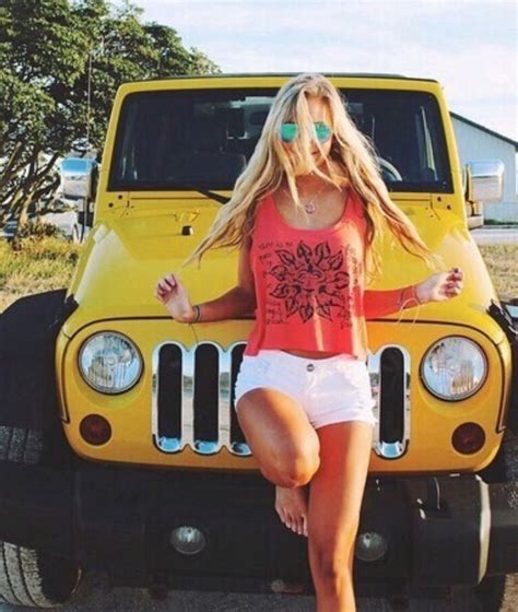 A Woman Standing In Front Of A Yellow Jeep With Her Legs Crossed And