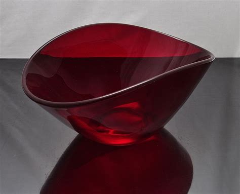 A Red Glass Bowl Sitting On Top Of A Table