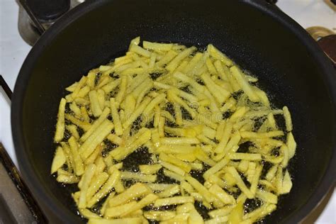 Frying French Fries In Sunflower Oil In A Frying Pan Stock Photo