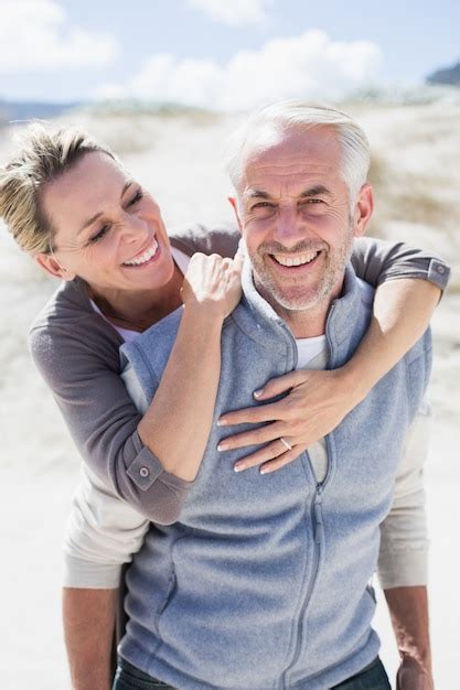 Premium Photo Happy Hugging Couple On The Beach Looking At Camera