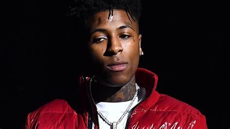 Nba Youngboy Is Wearing White T Shirt And Red Overcoat Standing In