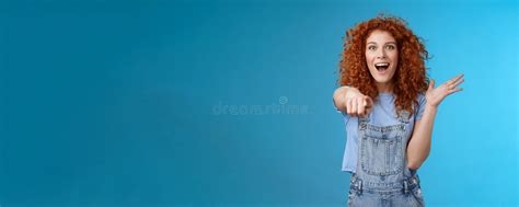excited impressed surprised cute redhead european woman curly astonished happily pointing index