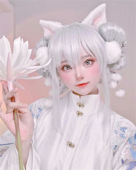 A Woman With White Hair And Cat Ears Holding A Flower In Front Of Her Face