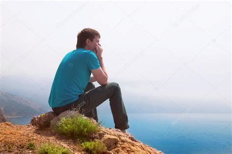 Одинокий парень глядящий вдаль в море стоковая фотография