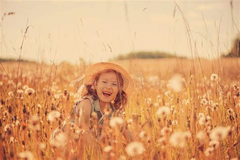 Happy Child Girl Walking On Summer Meadow With Dangelions Rural