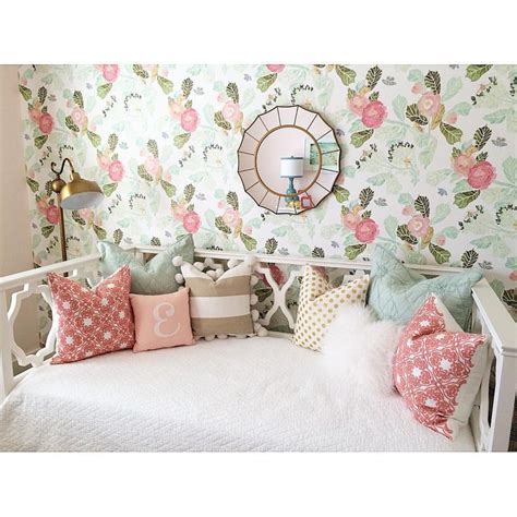 A White Bed Sitting In A Bedroom Next To A Wall Covered In Floral Wallpaper