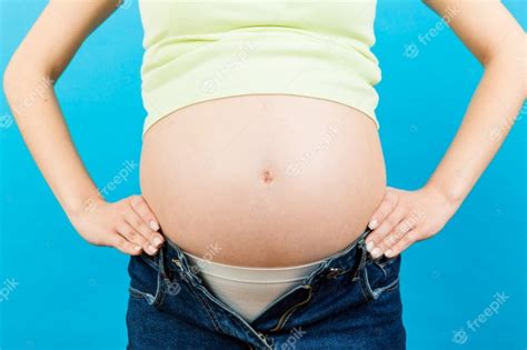 Schwangere Frau In Entpackten Jeans Zeigt Ihren Nackten Bauch Premium Foto