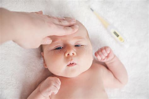 La Madre Controlla La Temperatura Di Un Bambino Malato Immagine Stock