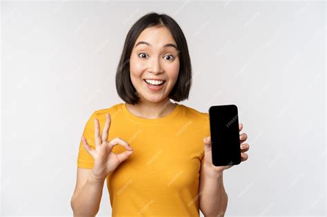 Free Photo Excited Asian Girl Showing Mobile Phone Screen Okay Sign