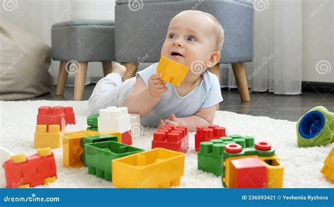 Portrait Of Cute Baby Boy Playing With Toy Bricks And Blocks At Home