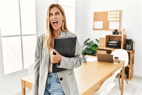 Blonde Business Woman At The Office Angry And Mad Screaming Frustrated