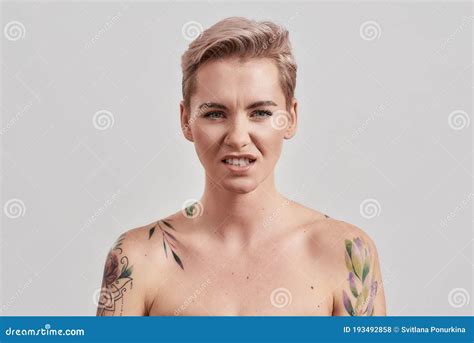 E Portrait Of Arrogant Half Naked Tattooed Woman With Pierced Nose And Short Hair Frowning