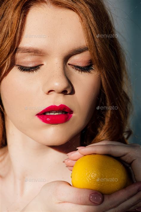 Beautiful Sensual Redhead Girl With Red Lips Posing With Lemon Stock