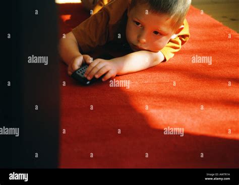 Little Boy Lying On Floor Holding Remote Control Stock Photo Alamy
