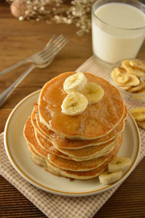 Stack Of Pancakes With Banana Slices And Honey On Wooden Background