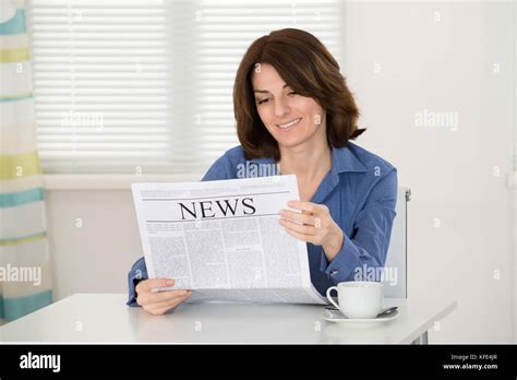 Happy Young Woman Reading Newspaper At Home Stock Photo Alamy