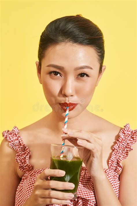 Smiling Young Asian Woman Drinking Green Fresh Vegetable Juice Or Smoothie From Glass Stock