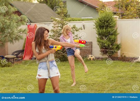 Young Friends Having A Squirt Gun Fight Stock Image Image Of Smiling