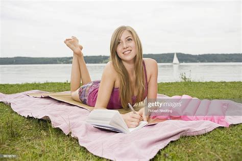 Germany Bavaria Starnberger See Young Woman Lying On Blanket Holding
