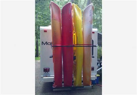 Three Surfboards Are Stacked On Top Of Each Other In Front Of A Camper