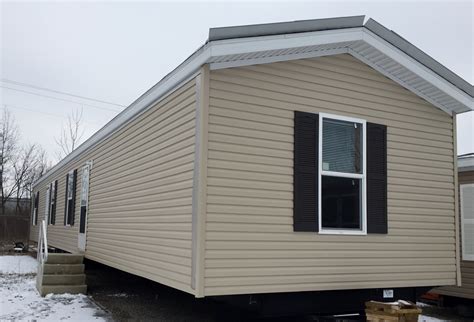 Here is a white house with charcoal shutters. SGL-2-tan-burgundy-shutters-single-wide | High Touch Homes
