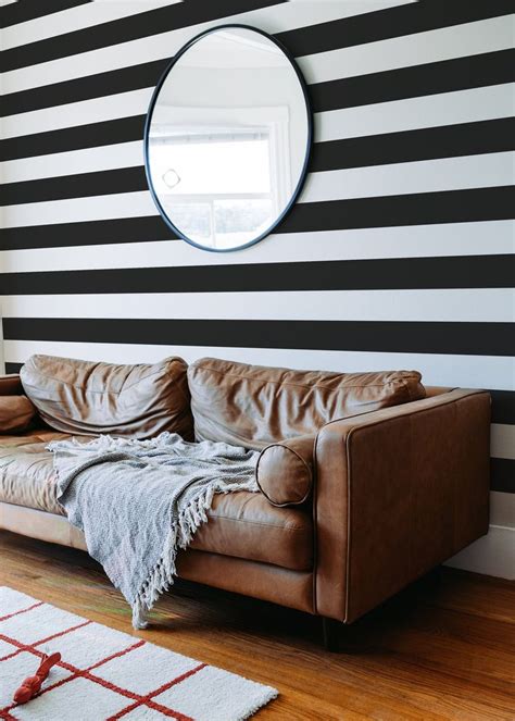 A Living Room With Black And White Stripes On The Wall Leather Couches