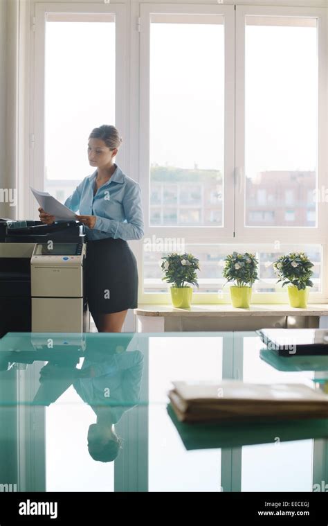 Female Secretary Working In Office Copying Document And Paperwork With