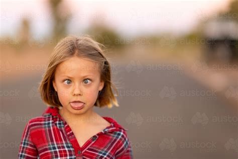 Image Of Little Girl Making Funny Face With Cross Eyes And Tongue Out
