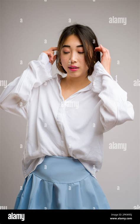 12 Half Body Portrait Of Young Asian Woman In A Short Blue Skirt And White Long Sleeve Blouse