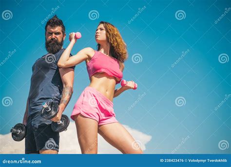 Sporty Couple Workout With Dumbbells Strong Man And Woman Working Out With Dumbbells On Sky