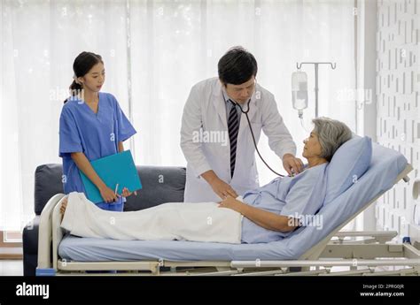 Senior Female Patient And Doctor Asian Doctor Use A Stethoscope To Check The Heartbeat Of The