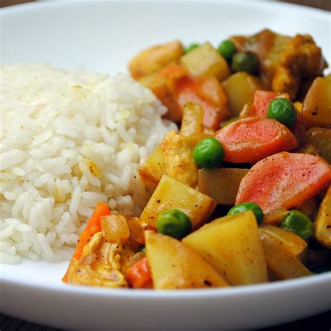 A mild rich and fragrant curry gravy, mixed with chicken, potatoes, carrots, and onions and hot steamed japanese rice, for serving. Japanese Chicken Curry