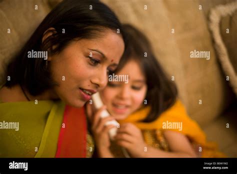 Pakistani Mother And Mixed Race Daughter In Traditional Dress Telephone